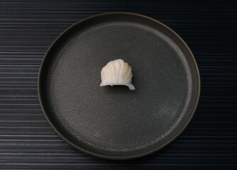 steamed har gao prawn wrapped in crystal skin dumpling on dark grey wood background dim sum menu