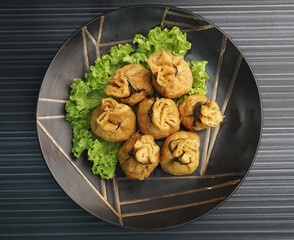 steamed bean curd skin wrapped with meat ball fortune bag dumpling on dark grey wood background dim sum menu