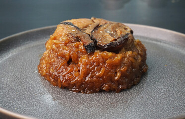 handmade steamed lomaigai sticky glutinous rice with chicken and mushroom on dark grey wood background Hong Kong dim sum menu