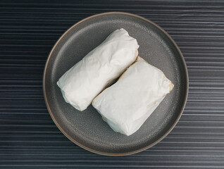 baked handmade paper wrapped chicken meat with herbal dark soy sauce on dark grey wood background dim sum menu