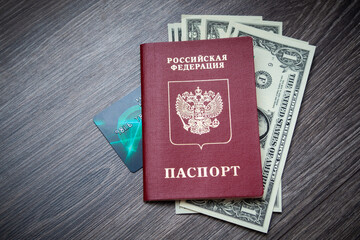 A foreign passport and dollars on a wooden background.