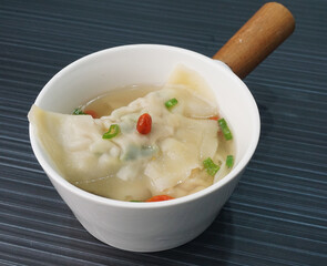handmade deep fried and boiled pork meat dumpling wanton soup on dark grey wood background dim sum menu     