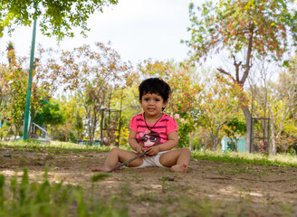 portrait of cute baby girl playing in the park.