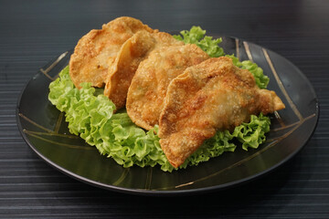handmade deep fried and boiled pork meat dumpling wanton soup on dark grey wood background dim sum menu     
