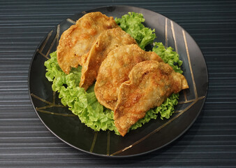 handmade deep fried and boiled pork meat dumpling wanton soup on dark grey wood background dim sum menu     