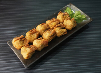 handmade deep fried and boiled pork meat dumpling wanton soup on dark grey wood background dim sum menu     