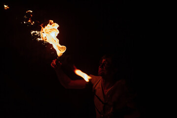 the fireshow artist exhales fire. a dangerous and beautiful performance of the street art theater....