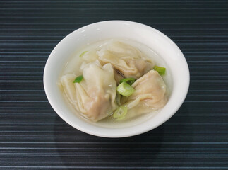 handmade deep fried and boiled pork meat dumpling wanton soup on dark grey wood background dim sum menu     