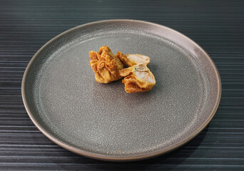 handmade deep fried and boiled pork meat dumpling wanton soup on dark grey wood background dim sum...