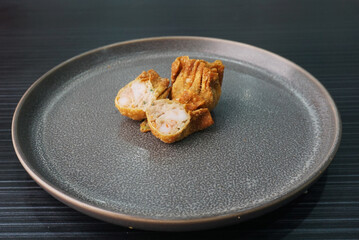 handmade deep fried and boiled pork meat dumpling wanton soup on dark grey wood background dim sum...