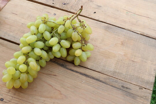 Green grapes on a wooden table