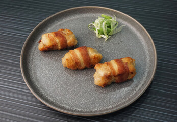 deep fried pork meatball wrapped with bacon roll on dark grey wood background dim sum menu