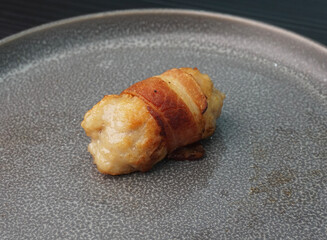 deep fried pork meatball wrapped with bacon roll on dark grey wood background dim sum menu
