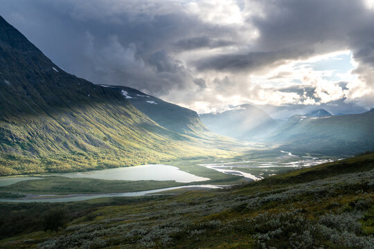 Remote harsh arctic landscape in rough weather in Sarek national park, Swedish Lapland. Heavy clouds with rays of light coming through.