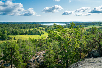 Beautiful summer day in Swedish landscape of Segersgarde nature reservation. Green forests, meadows view from the top of the rock. Summer holiday in Sweden. © Petr