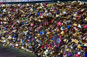 Close-up and selective focus of many love locks and padlocks with names and dates on the post neuf in Paris