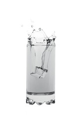 Water splashing out of glass creating an art shape isolated on white background.