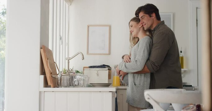 happy pregnant couple hugging proud husband embracing wife holding her belly excited for parenthood looking out window thinking of future 4k