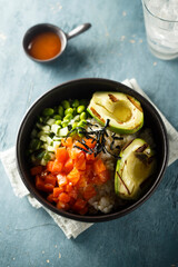 Healthy rice bowl with salmon and grilled avocado