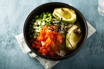 Healthy rice bowl with salmon and grilled avocado
