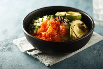 Healthy rice bowl with salmon and grilled avocado