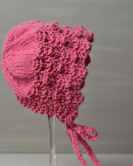 pretty pink knitted bonnet for a baby girl 