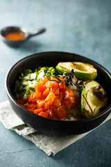 Healthy rice bowl with salmon and grilled avocado