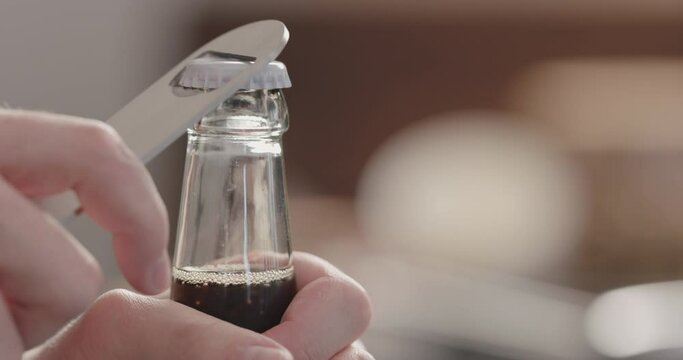 Slow motion man open glass bottle with fizzy drink
