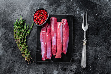 Fresh Raw lamb tenderloin Fillet, Mutton Sirloin Meat on marble board with thyme. Black background....