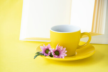 Fototapeta na wymiar ピンクの小菊と本とコーヒー（黄色の背景）