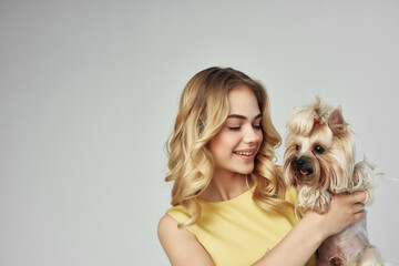 woman in a yellow dress fun a small dog isolated background