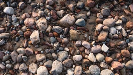 pebble stones by the sea. Silky waves of blue sea from long exposure.