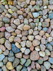 Large stones of different colors are folded tightly to each other, texture for the background. Good quality vertical photo