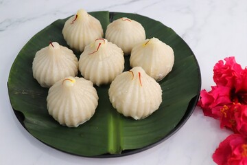 Steamed or ukdiche Modak. It's a traditional sweet dish made out of coconut, jaggery and dry fruits stuffed inside rice dough. Offered to Lord Ganesha during Ganpati festival in India. with copy space