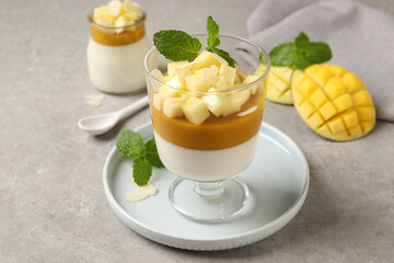 Delicious panna cotta with mango on grey table