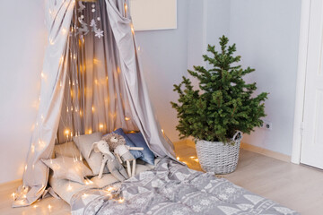 Stylish modern children's room. Children's bed with awning. Christmas tree in a wicker basket. Scandinavian style interior