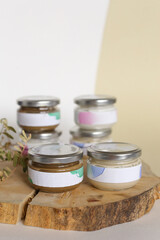 Eco friendly Glass Bottle or jar with natural skincare cosmetics, creams or oils on light background. Plant-based beauty products