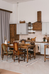Kitchen table with food and kitchenware with a variety of wooden chairs in the Scandinavian style