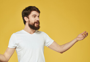 emotional bearded man in white t-shirt yellow background