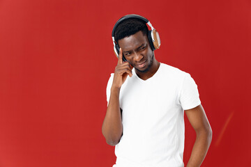 man of african appearance in headphones next to technology clock