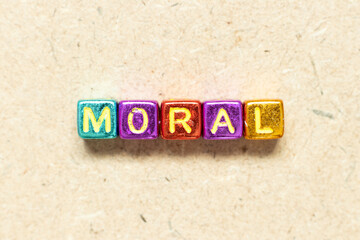 Metallic color alphabet letter block in word moral on wood background