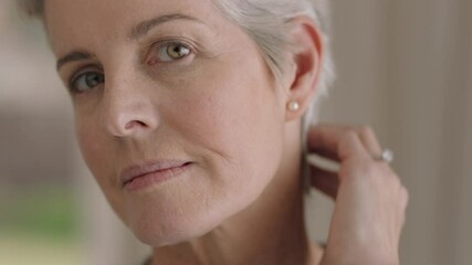 portrait beautiful mature woman looking in mirror at perfect healthy skin touching face with hands enjoying smooth natural complexion with anti aging skincare getting ready at home beauty concept