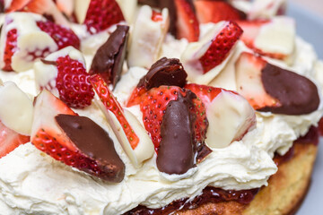 A homemade Keto sponge cake featuring whipped cream, and strawberries whipped in two kinds of chocolate