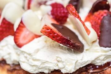A homemade Keto sponge cake featuring whipped cream, and strawberries whipped in two kinds of chocolate