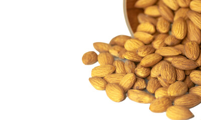 almonds poured out of a cup on a white background