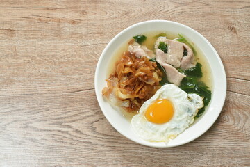 stir fried large rice noodles black soybean dressing fermenting pork and Chinese kale in gravy sauce topping egg on plate