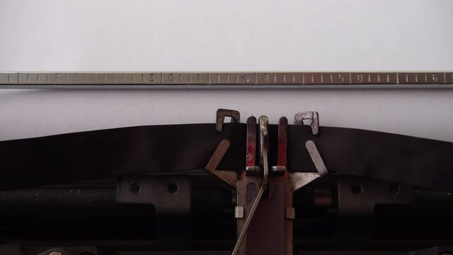 Typing alphabet letters A B C D E F G H I J K L M N O P Q on retro typewriter. Close up.