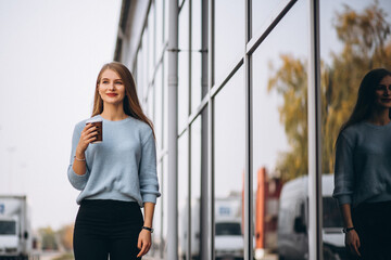 Fototapeta premium Young woman drinking coffee by the cafe