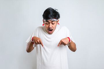 Naklejka premium Man wearing casual shirt standing pointing down with fingers showing advertisement, surprised face and open mouth