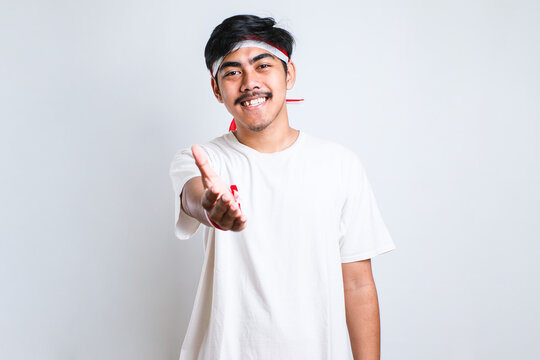 man wearing casual clothes smiling friendly offering handshake as greeting